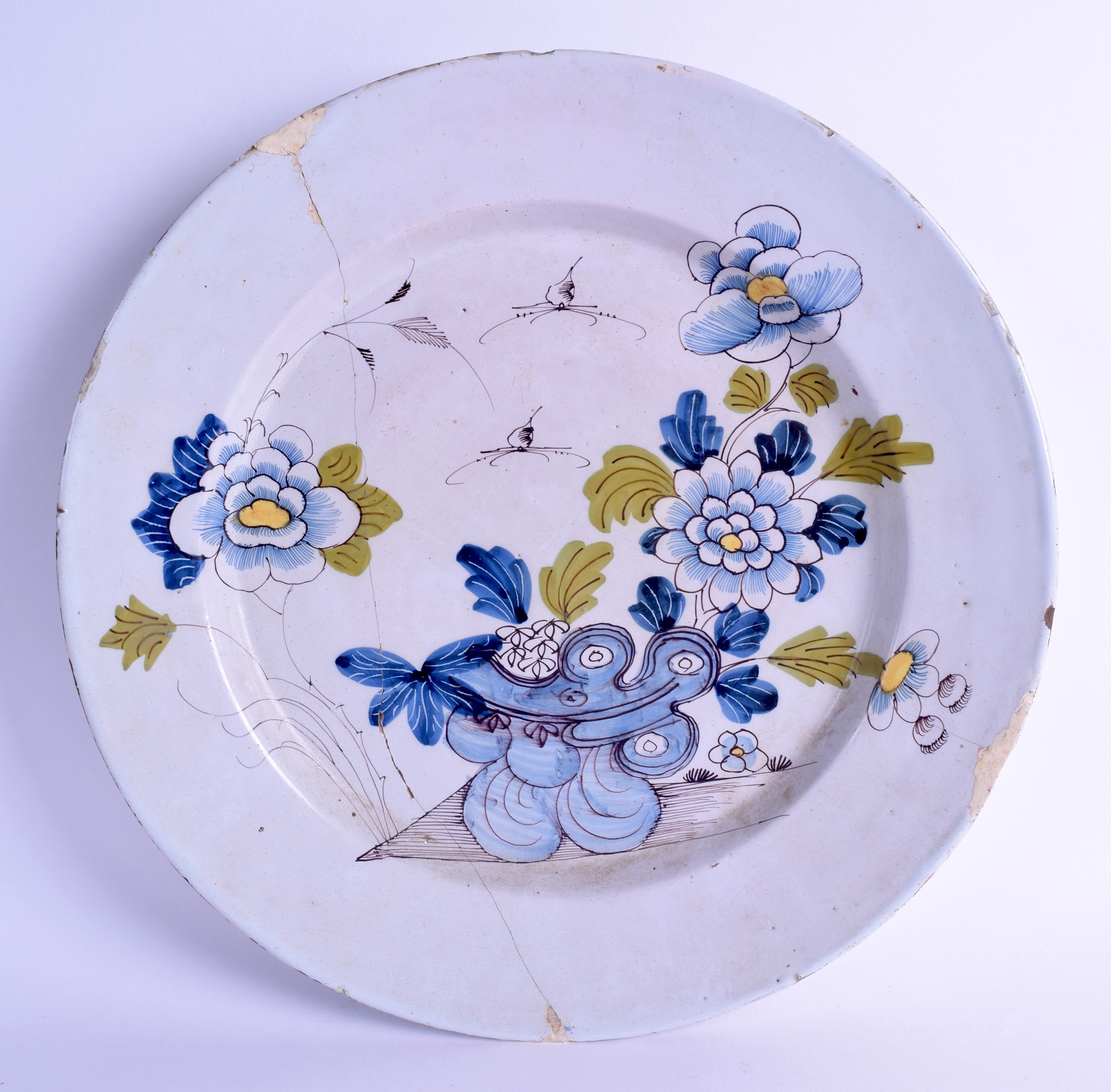 A LARGE 18TH CENTURY DELFT FAIENCE TIN GLAZED CHARGER painted with insects, flowers and hollow rock.