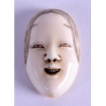 A 19TH CENTURY JAPANESE MEIJI PERIOD CARVED IVORY NOH MASK/NETSUKE in the form of a female. 2.5 cm x