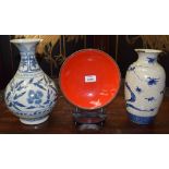 A STUDIO POTTERY RED GLAZED DISH ON STAND, together with two chinese blue & white vases. (3)