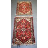 A PAIR OF ANTIQUE PERSIAN RED GROUND RUGS, decorated with foliage. 85 cm x 55 xm.