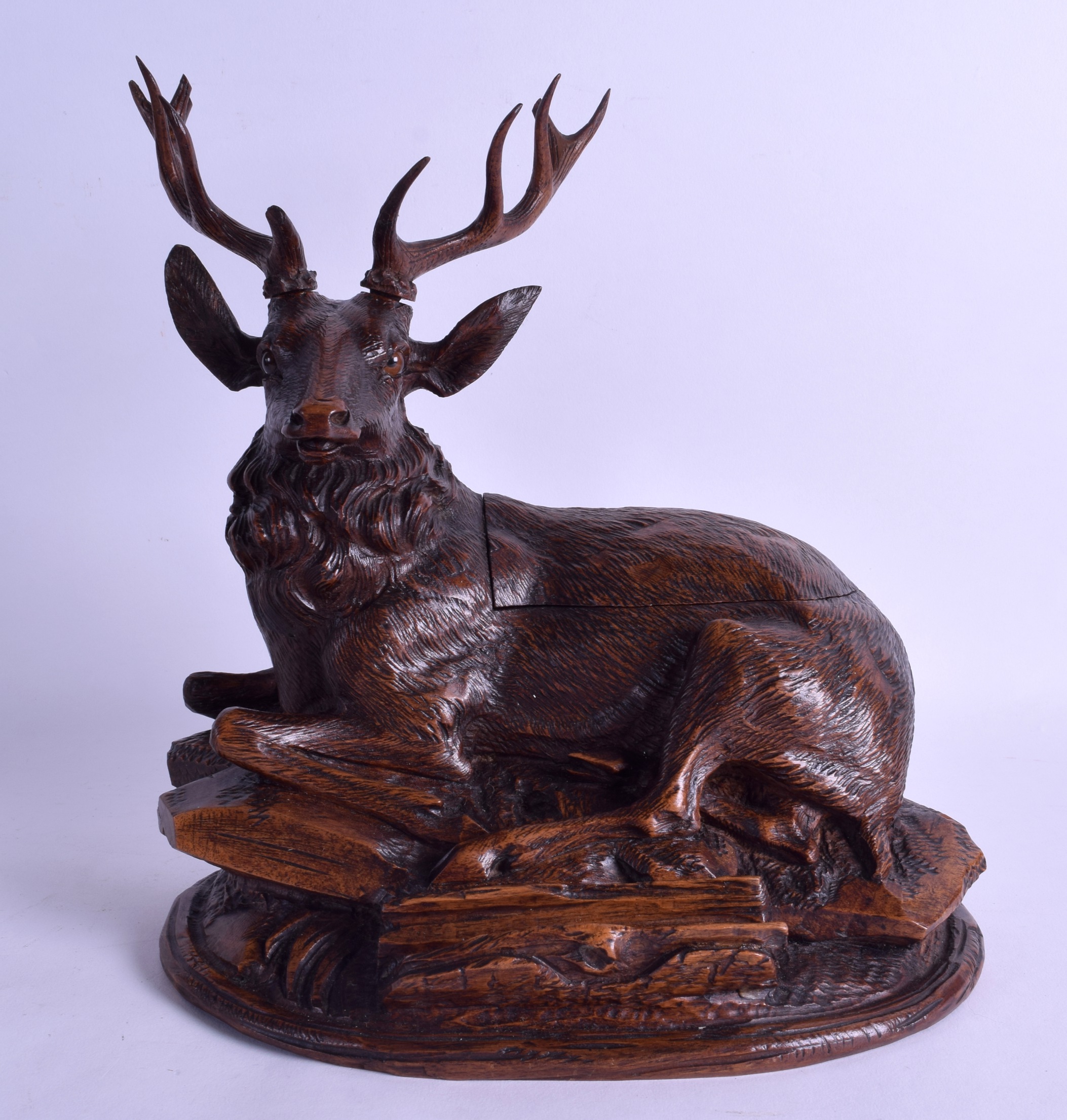 A FINE 19TH CENTURY BAVARIAN BLACK FOREST CARVED WOOD INKWELL in the form of a seated stag upon a