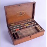 AN UNUSUAL ANTIQUE REEVES & SONS MAHOGANY PENCIL BOX the top rising to reveal a collection of