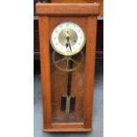 A 1950S ELECTRIC CLOCK with oak case and white circular dial. 91 cm x 35 cm.