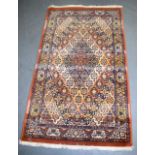 A RED GROUND PERSIAN RUG, decorated with foliage. 140 cm x 82 cm.