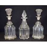 A PAIR OF ANTIQUE GLASS DECANTERS, together with another similar. 27 cm high.