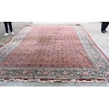 A MONUMENTAL RED GROUND PERSIAN CARPET, decorated with flowers. 650 cm x 362 cm.