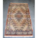 A RED GROUND PERSIAN RUG, decorated with foliage. 140 cm x 82 cm.