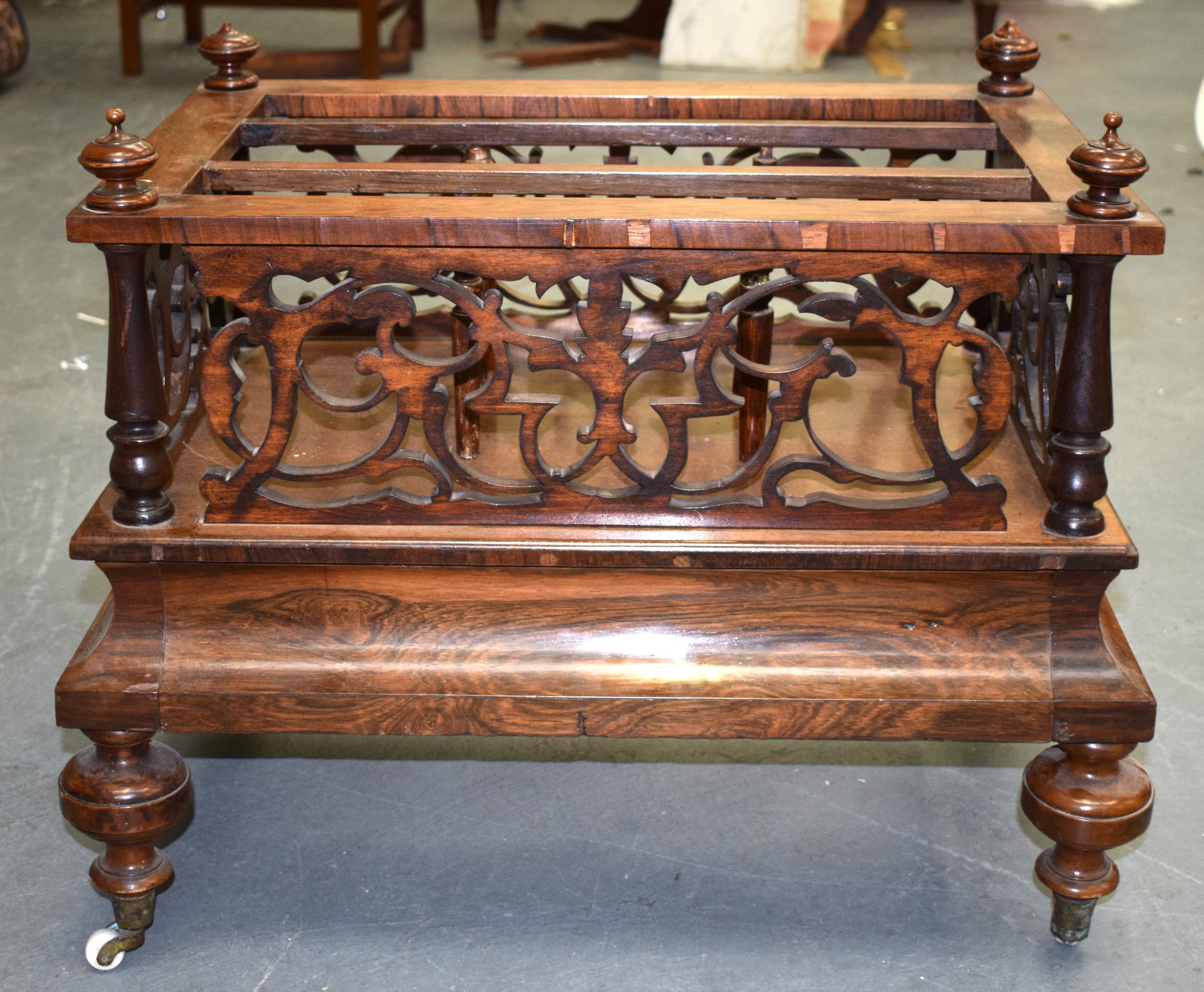 A VICTORIAN FIGURED WALNUT CANTERBURY, with carved fretwork and turned upright supports. 64 cm