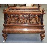 A VICTORIAN FIGURED WALNUT CANTERBURY, with carved fretwork and turned upright supports. 64 cm