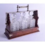 A LATE VICTORIAN/EDWARDIAN MAPPIN & WEBB TANTALUS set with three cut glass decanters and stoppers.