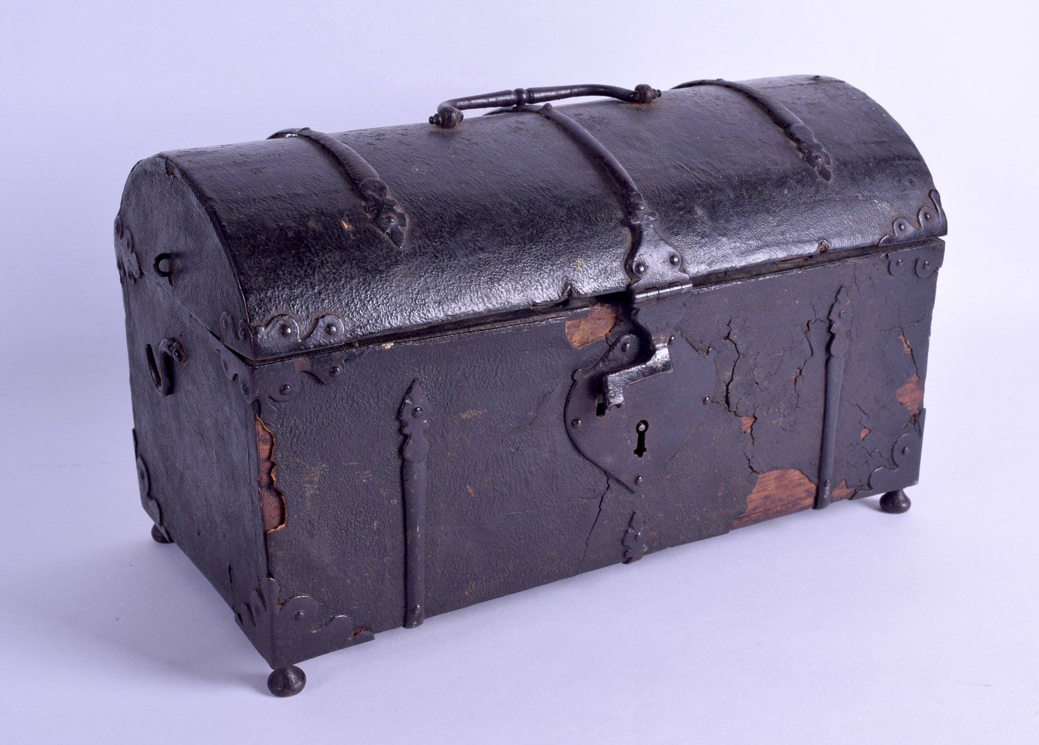 A GOOD 17TH CENTURY MIDDLE EUROPEAN LEATHER OVERLAID CASKET with iron mounts, supported upon bun