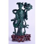 AN EARLY 20TH CENTURY CHINESE CARVED MALACHITE FIGURE OF GUANYIN modelled holding a floral sprig.