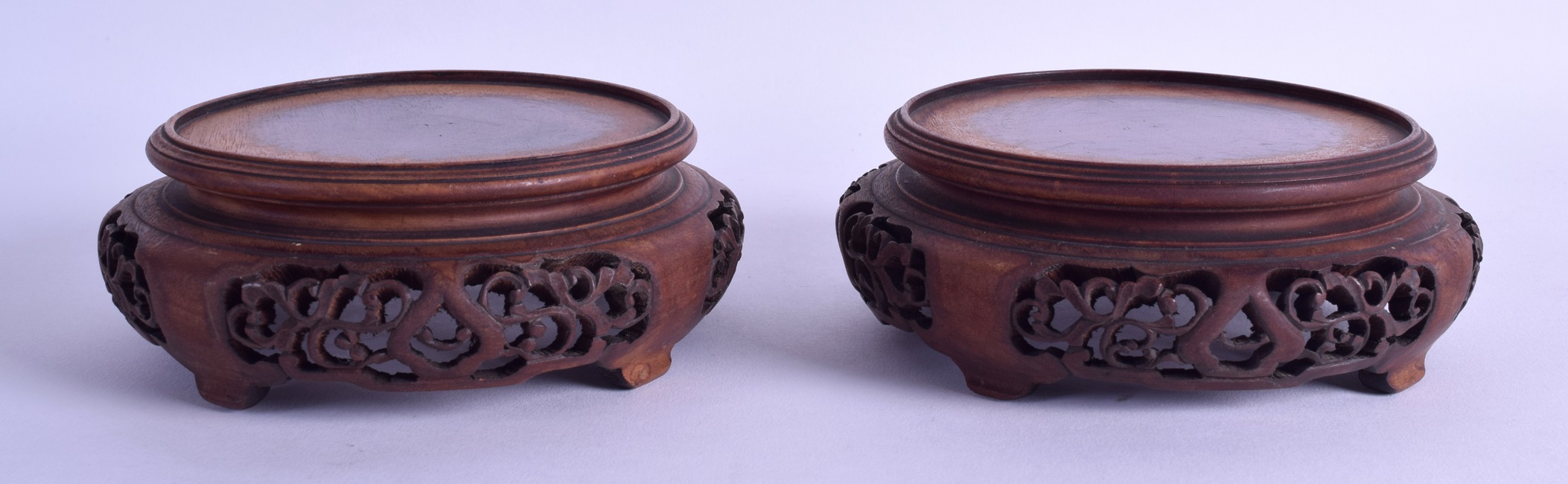 A PAIR OF EARLY 20TH CENTURY CHINESE CARVED HARDWOOD STANDS decorated with openwork foliage. 13.25 - Image 2 of 2