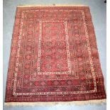 A RED GROUND ANTIQUE PERSIAN RUG, decorated with foliage and motifs.137 cm x 107 cm.