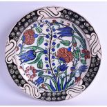 A CONTINENTAL PERSIAN TURKISH IZNIK STYLE CIRCULAR POTTERY BOWL painted with flowers. 26 cm