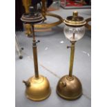 AN UNSUAL NEAR PAIR OF ANTIQUE BRASS TILLEY LAMPS, one with reeded column & the other plain. 50 cm