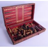 A GOOD LARGE MID 19TH CENTURY CARVED BOXWOOD CHESS SET with other gaming counters, encased within