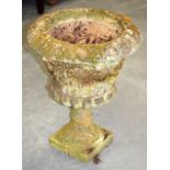 AN EARLY 20TH CENTURY STONE URN ON STAND, decorated with foliage. 56 cm x 43 cm.