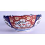 A JAPANESE TAISHO PERIOD IMARI SCALLOPED BOWL painted with urns of foliage. 25 cm diameter.