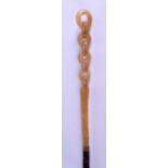 AN UNUSUAL EARLY 20TH CENTURY CARVED LUCITE WALKING CANE Horn style, with bamboo shaft. 93 cm long.