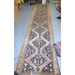 A LARGE ANTIQUE PERSIAN BLUE GROUND RUNNER, decorated with foliage. 580 cm x 104 cm