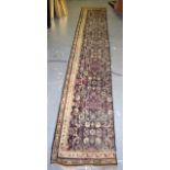 A PERSIAN RED GROUND RUNNER, decorated with foliage.338 cm x 56 cm.