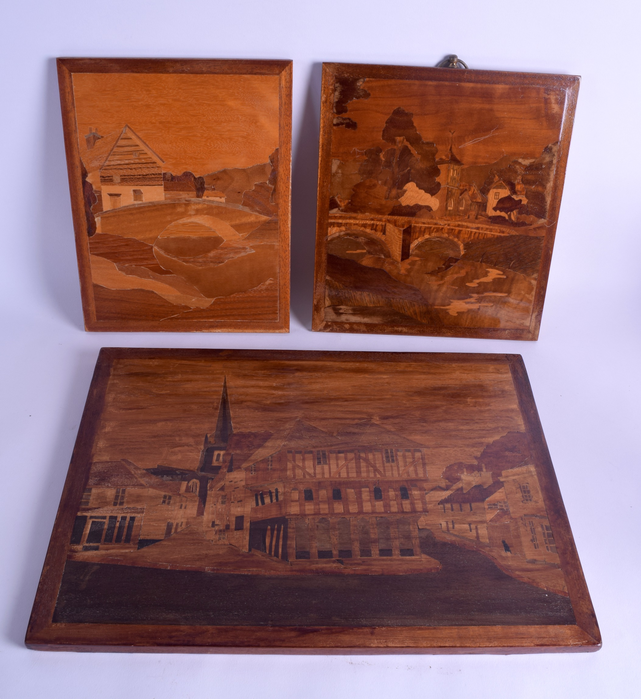 A SET OF THREE EARLY 20TH CENTURY PARQUETRY PANELS depicting landscapes and houses. Largest 39 cm