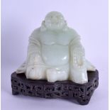 AN EARLY 20TH CENTURY CHINESE CARVED JADE FIGURE OF A BUDDHA modelled upon a silver inlaid base.