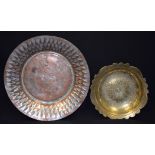 AN EASTERN BRASS SHALLOW BOWL, decorated with animals, together with a copper dish. largest 30 cm