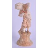 Royal Worcester figure of a girl with a tambourine standing on a tree stump painted in blush ivory