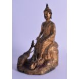 A MID 19TH CENTURY SOUTH EAST ASIAN GILT BRONZE BUDDHISTIC FIGURE modelled beside an elephant and