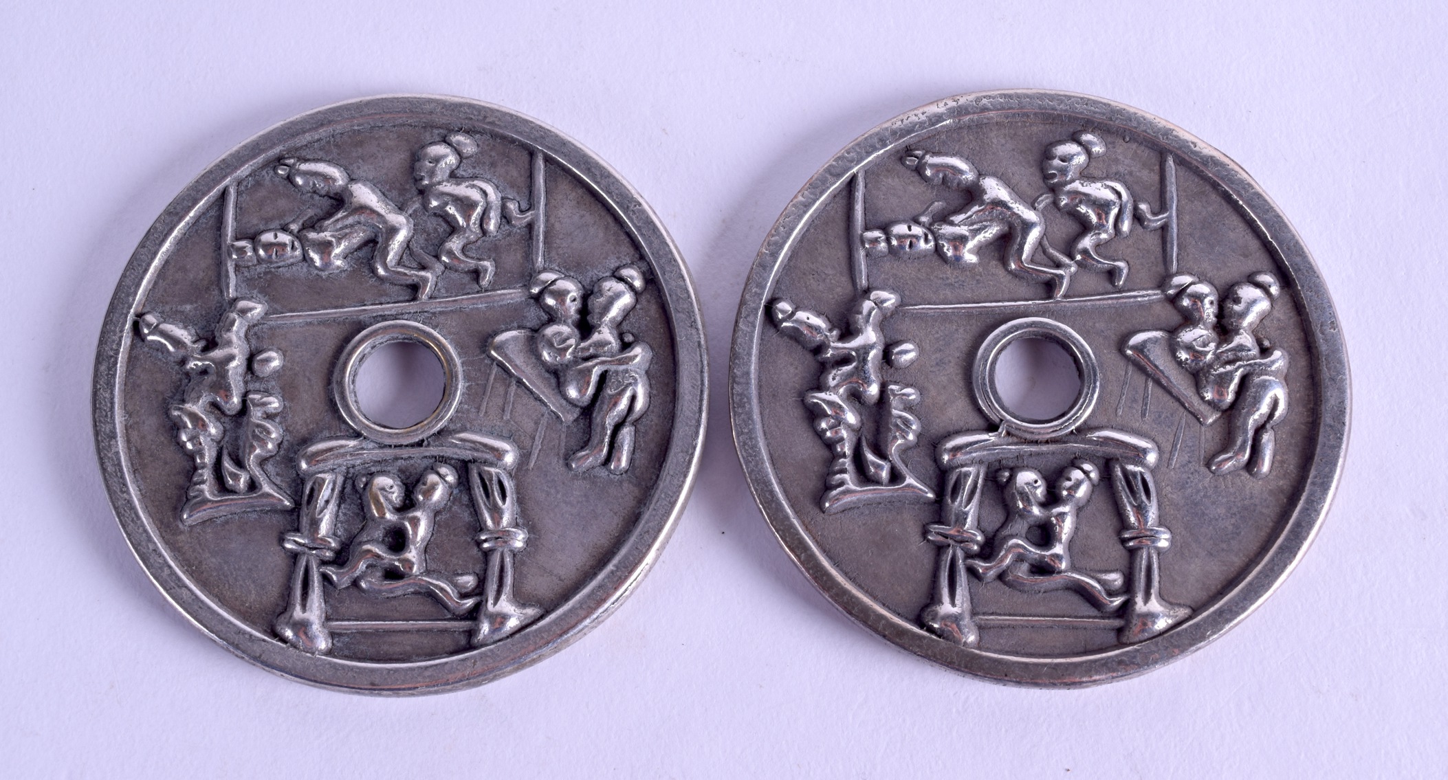 A PAIR OF CHINESE WHITE METAL CIRCULAR COINS decorated with figures in erotic pursuits. 7 cm - Bild 2 aus 2