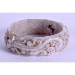 A CHINESE CARVED JADE BANGLE decorated with dragons and foliage. 7.5 cm diameter.