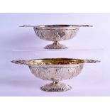 A PAIR OF 18TH CENTURY CONTINENTAL TWIN HANDLED SILVER PEDESTAL BOWLS decorated in relief with a