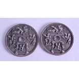 A PAIR OF CHINESE WHITE METAL CIRCULAR COINS decorated with figures in erotic pursuits. 7 cm