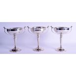 A GOOD SET OF THREE 1930S SILVER TWIN HANDLED CUPS. London 1933. 26 oz. 19 cm x 17 cm. (3)