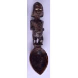 AN AFRICAN CARVED WOOD SPOON modelled with a standing male with genitals exposed. 24 cm long.