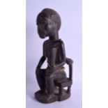 AN AFRICAN CARVED HARDWOOD FIGURE OF A VILLAGE ELDER modelled upon a chair wearing a cloth rag. 36