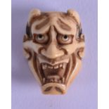 AN EARLY 19TH CENTURY JAPANESE EDO PERIOD CARVED IVORY NOH MASK/NETSUKE in the form of a scowling