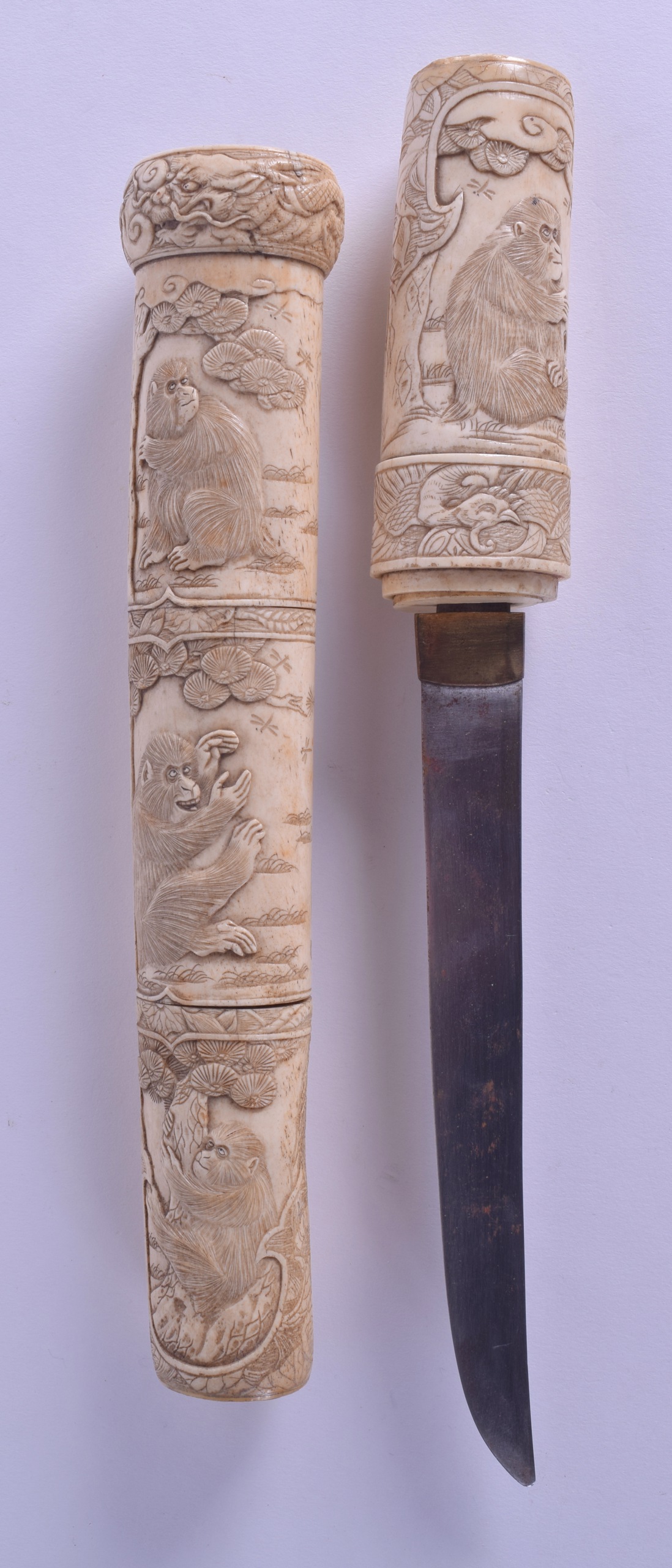 A 19TH JAPANESE MEIJI PERIOD CARVED IVORY TANTO DAGGER unusually carved with monkeys within