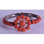 AN UNUSUAL WHITE METAL MOUNTED CARVED CORAL BANGLE. 7.25 cm wide.
