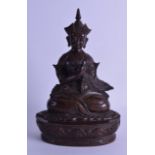 A LARGE 18TH/19TH CENTURY TIBETAN BRONZE FIGURE OF A SEATED MALE modelled with hands crossed, upon a