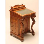 A VICTORIAN WALNUT DAVENPORT, the raised cushioned back with waved gallery and hinged lid opening to