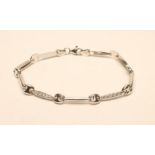A 9CT WHITE GOLD AND DIAMOND BRACELET with four eliptical panels set with millegrain set stones