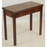 A GEORGIAN MAHOGANY FOLDING TEA TABLE, of oblong form with moulded edged top, plain frieze, raised
