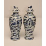 A PAIR OF CHINESE PORCELAIN VASES AND COVERS, of inverted baluster form, painted in underglaze