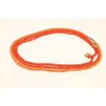 A PAIR OF VICTORIAN POLISHED CORAL BEAD NECKLACES, together with another pale coral graduated bead