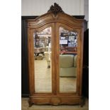 A FRENCH WALNUT ARMOIRE, c.1900, the arched moulded cornice centred by a carved foliate and shell