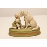 A ROYAL DUX BISQUE PORCELAIN FIGURE, early 20th century, modelled as a toddler beside a retriever,