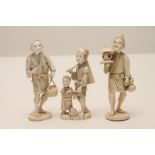 THREE JAPANESE IVORY OKIMONO, Meiji period, carved as a fisherman and his son and two traders, one